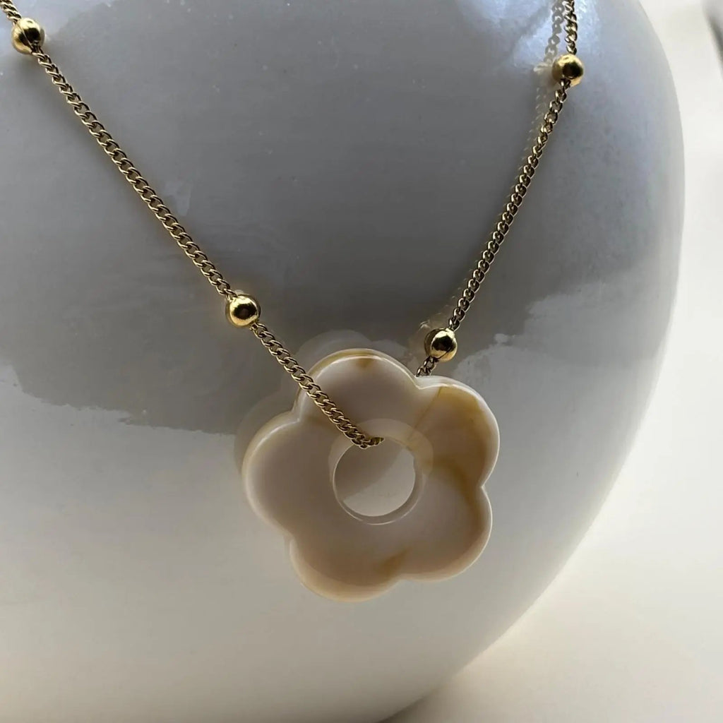 Collier fantaisie avec une chainette dorée et perles dorées un pendentif fleur colorée écru en acier inoxydable