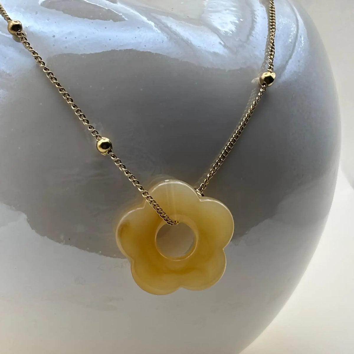 Collier fantaisie avec une chainette dorée et perles dorées un pendentif fleur colorée jauneen acier inoxydable