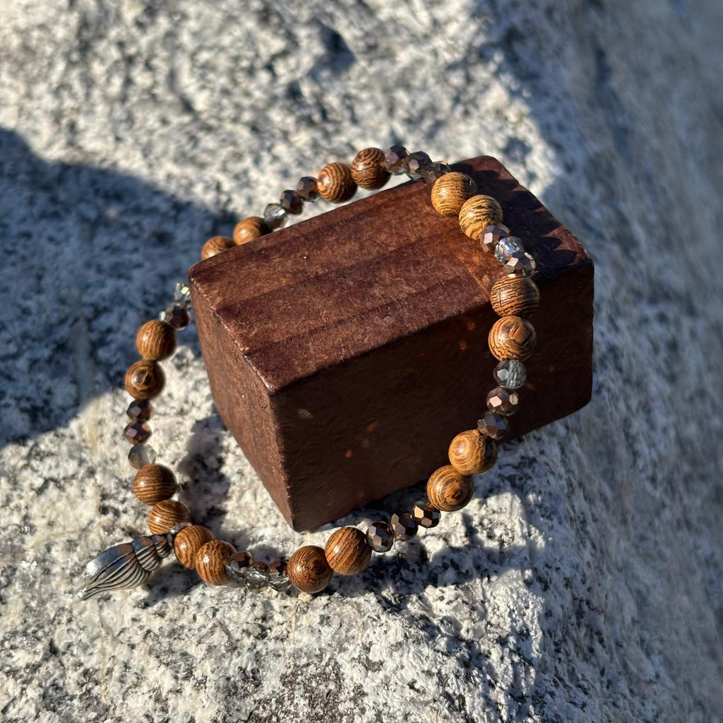Bracelet en perles artisanal  avec breloque coquillage argenté et perles en bois sur élastique