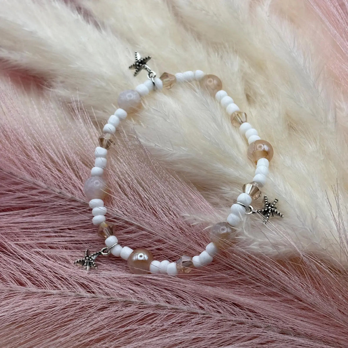 Bracelet en perles artisanal avec breloques étoiles de mer argentées et perles de verre blanche sur élastique