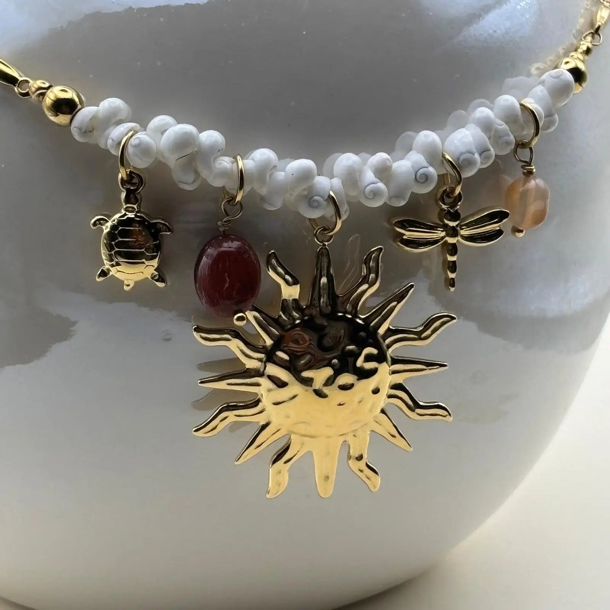 Collier fantaisie avec un  pendentif et breloques soleil perles tortue libellule petit coquillage de mer blanc