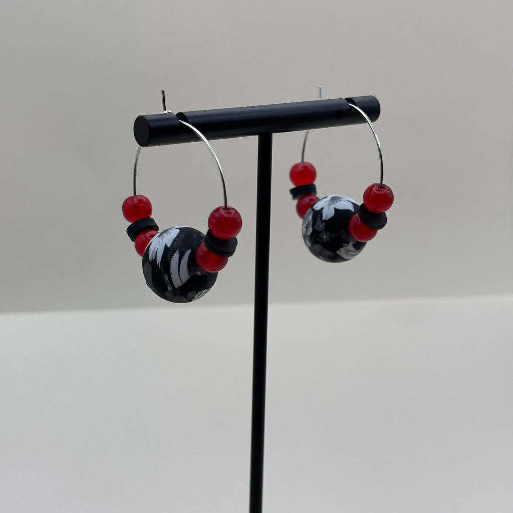 Boucles d'oreilles créoles argentées avec un grosse perle noire et blanche et de petites perles rouges v