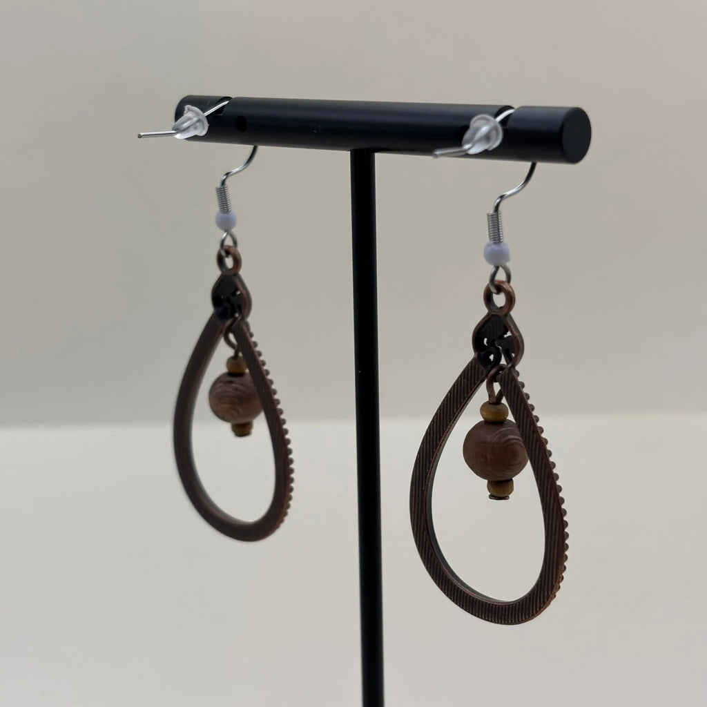 Des boucles d'oreilles en bois en forme de goutte avec des perles suspendues au centre