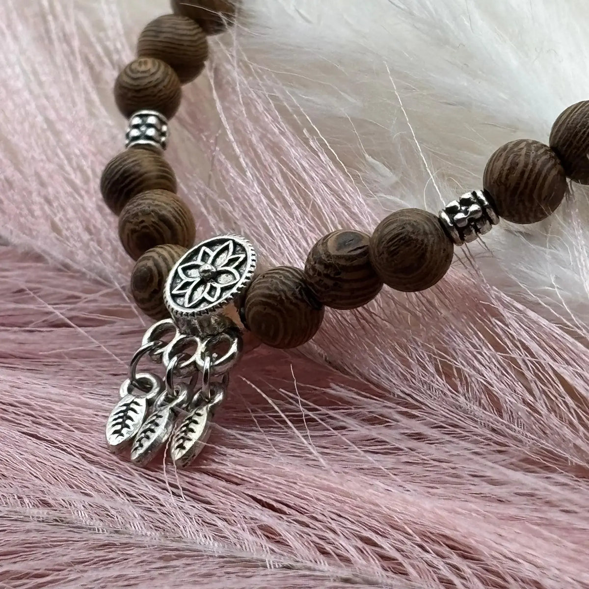 Vue de près d'un Bracelet en perles artisanal  avec breloque attrape rêve et perles en bois vendu