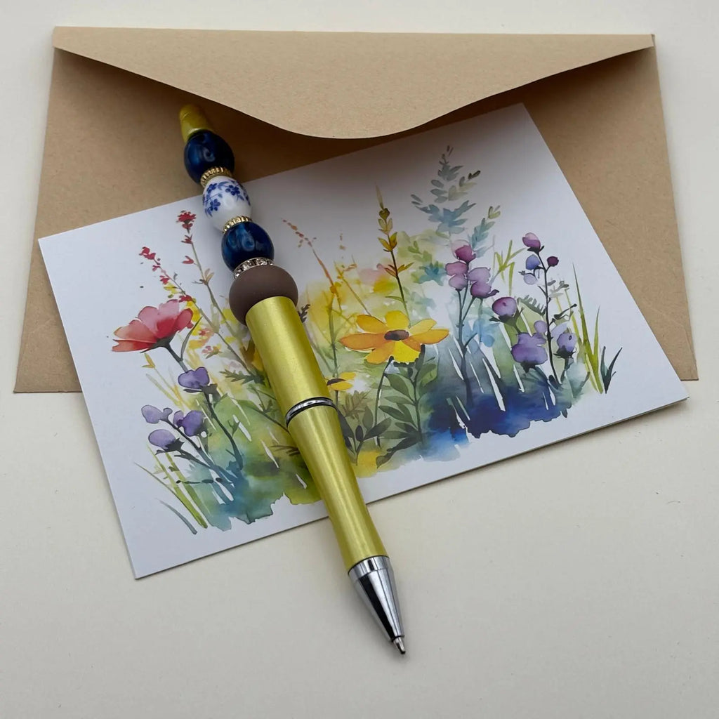 Stylo à bille à mine noire rétractable jaune et perles bleues et blanches 