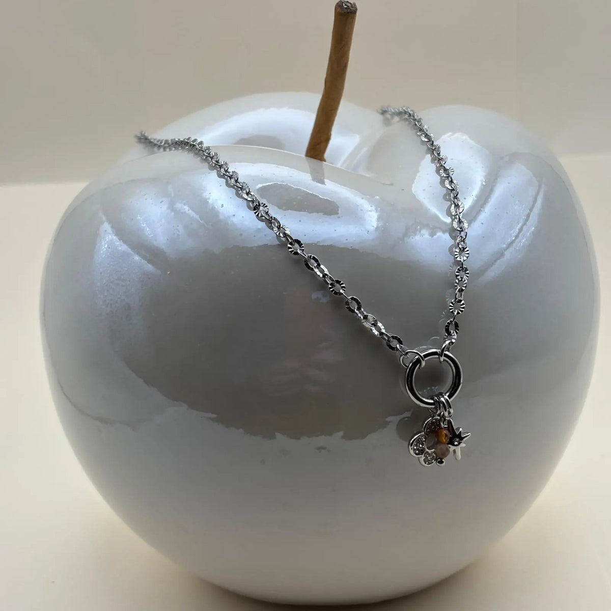 Un collier argenté avec breloques soleil fleur et perles en acier inoxydable