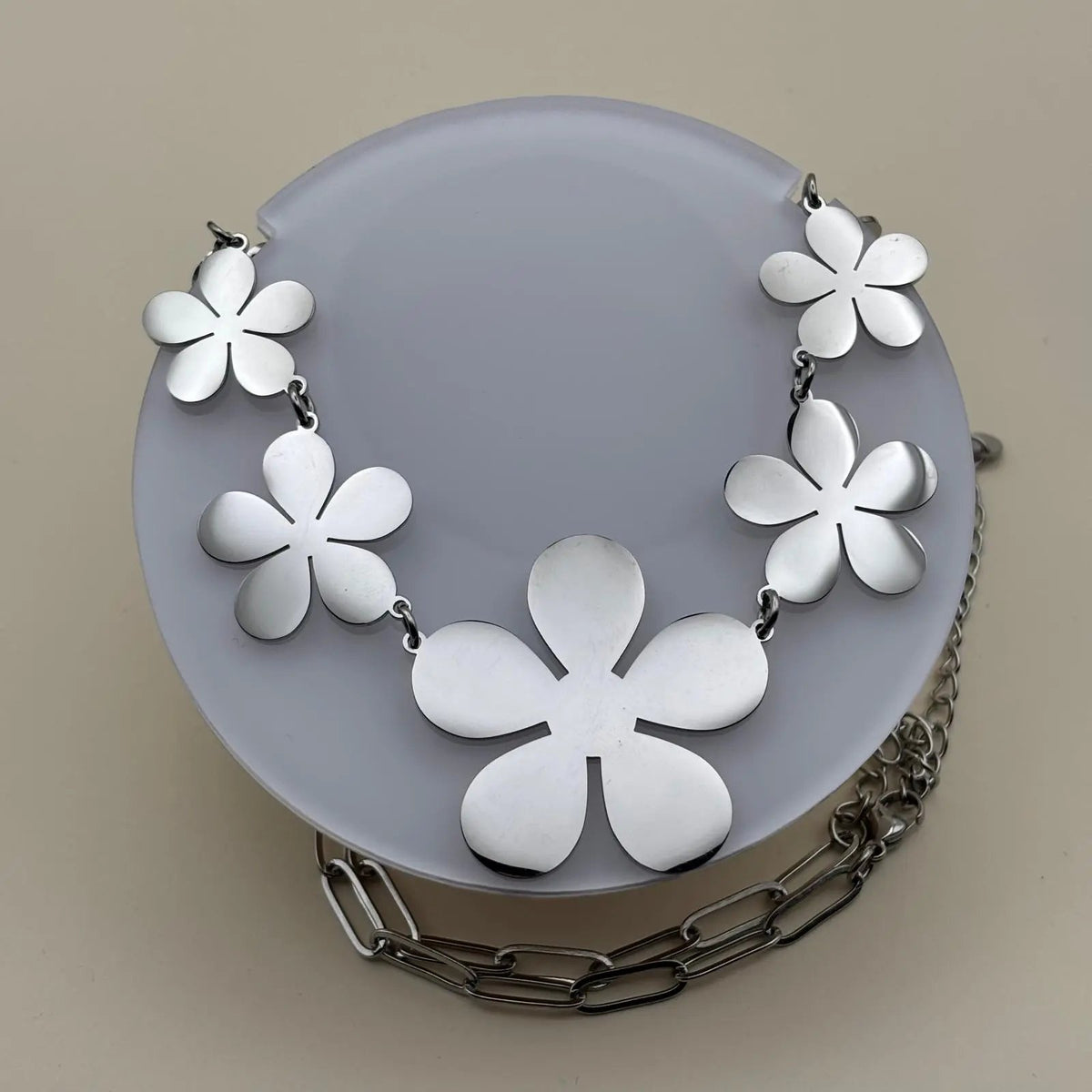 Un collier de couleur argenté avec des motifs de fleurs à cinq pétales en acier inoxydable