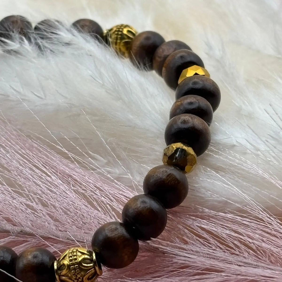 Vue de près d'un bracelet artisanal en perles avec perles ethniques dorées et en bois sur élastique