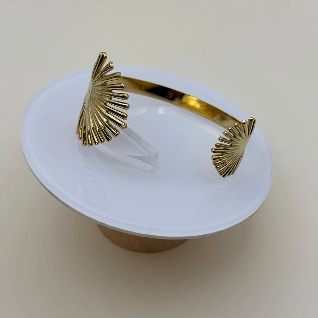 Bracelet rigide de couleur dorée ouvert avec motif feuille de palmier dorée