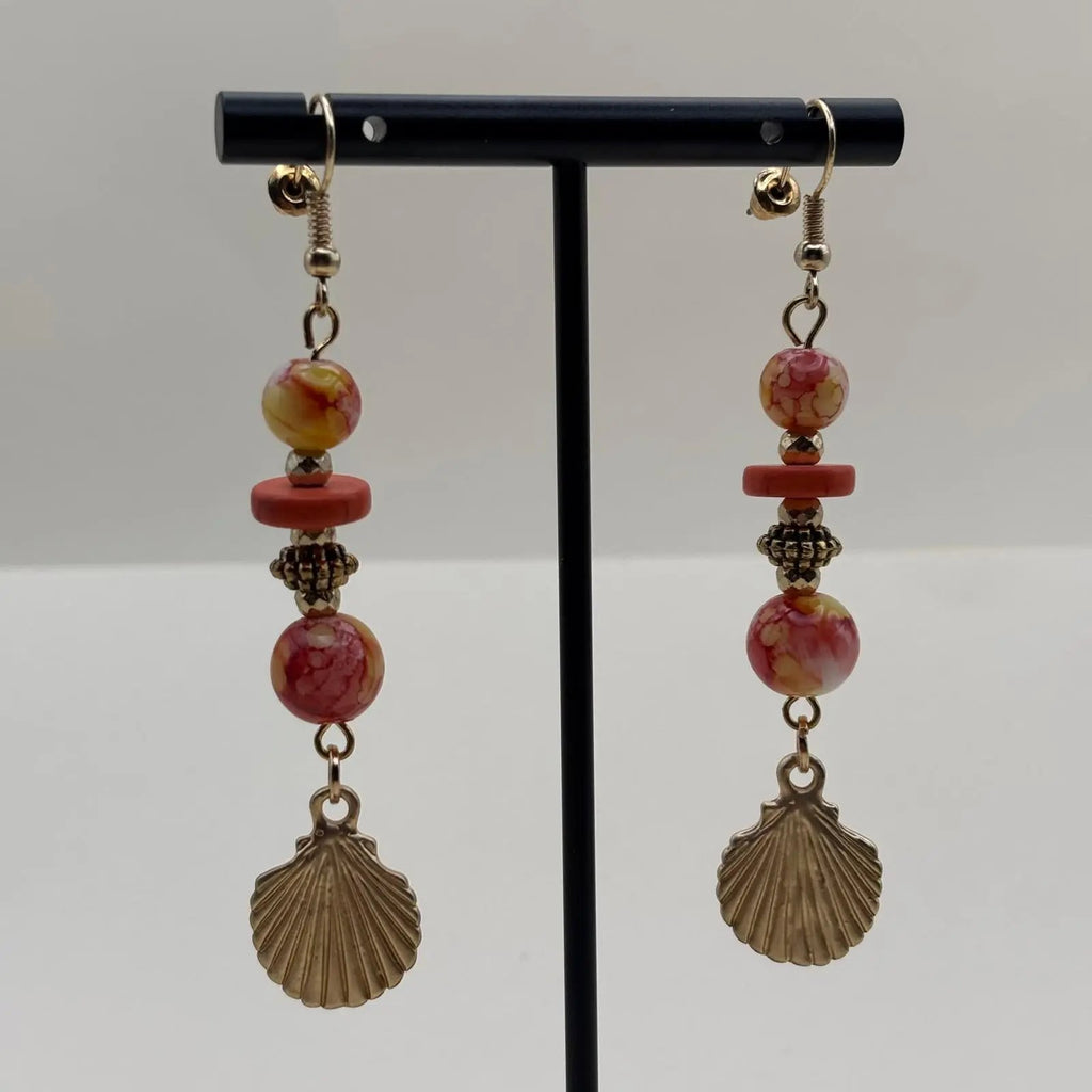 Boucles d'oreilles pendantes avec des perles orangées et jaune et un charms coquillage dorés