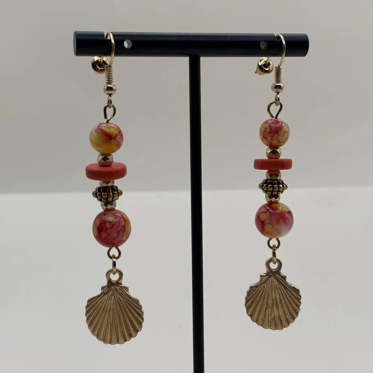 Boucles d'oreilles pendantes avec des perles orangées et jaune et un charms coquillage dorés