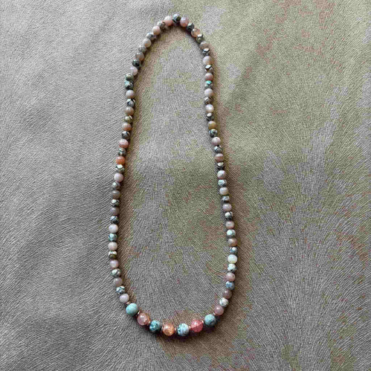 Vue de près d'un collier artisanal en perles naturelles saumon perles bicolores  sur élastique vendu sur le site internet prêtes à briller