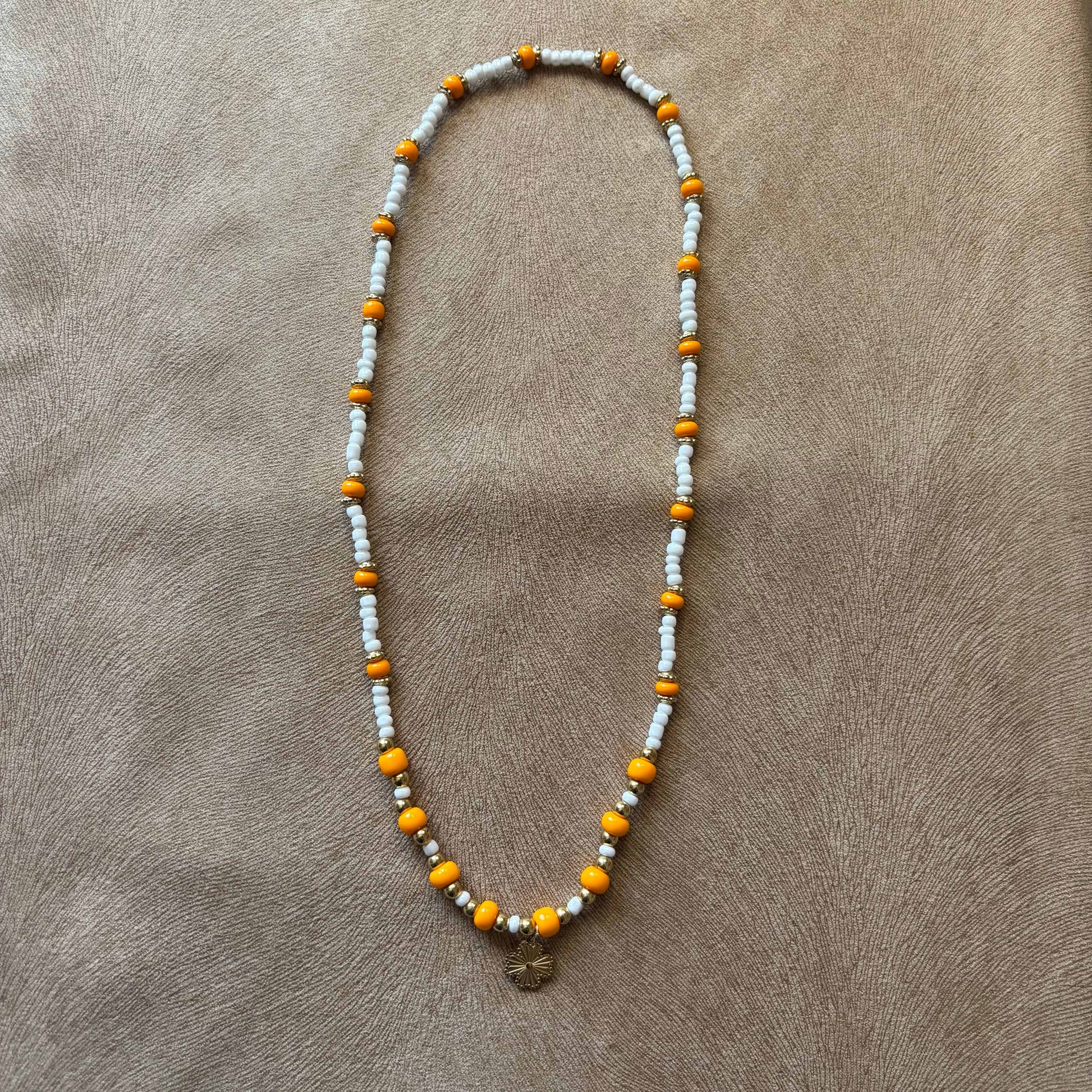Collier artisanal |Collier avec breloque fleur dorée | Perles de verre blanches et acrylique orange sur élastique