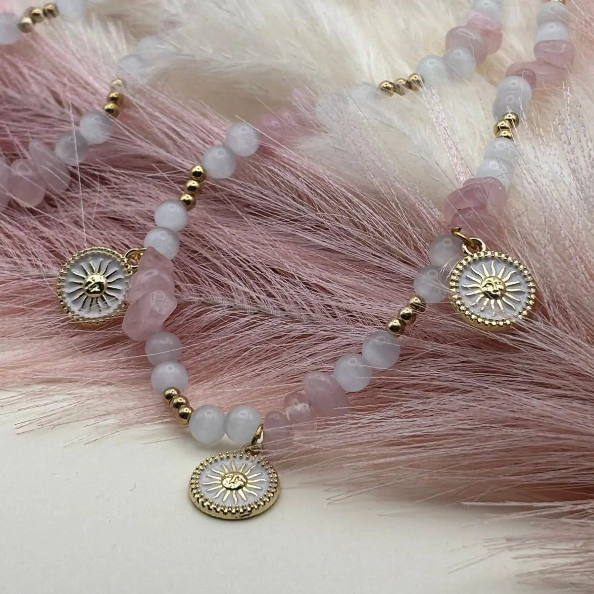 Collier artisanal en perles rose et blanches avec pendentifs décoratifs en forme de soleil bijou