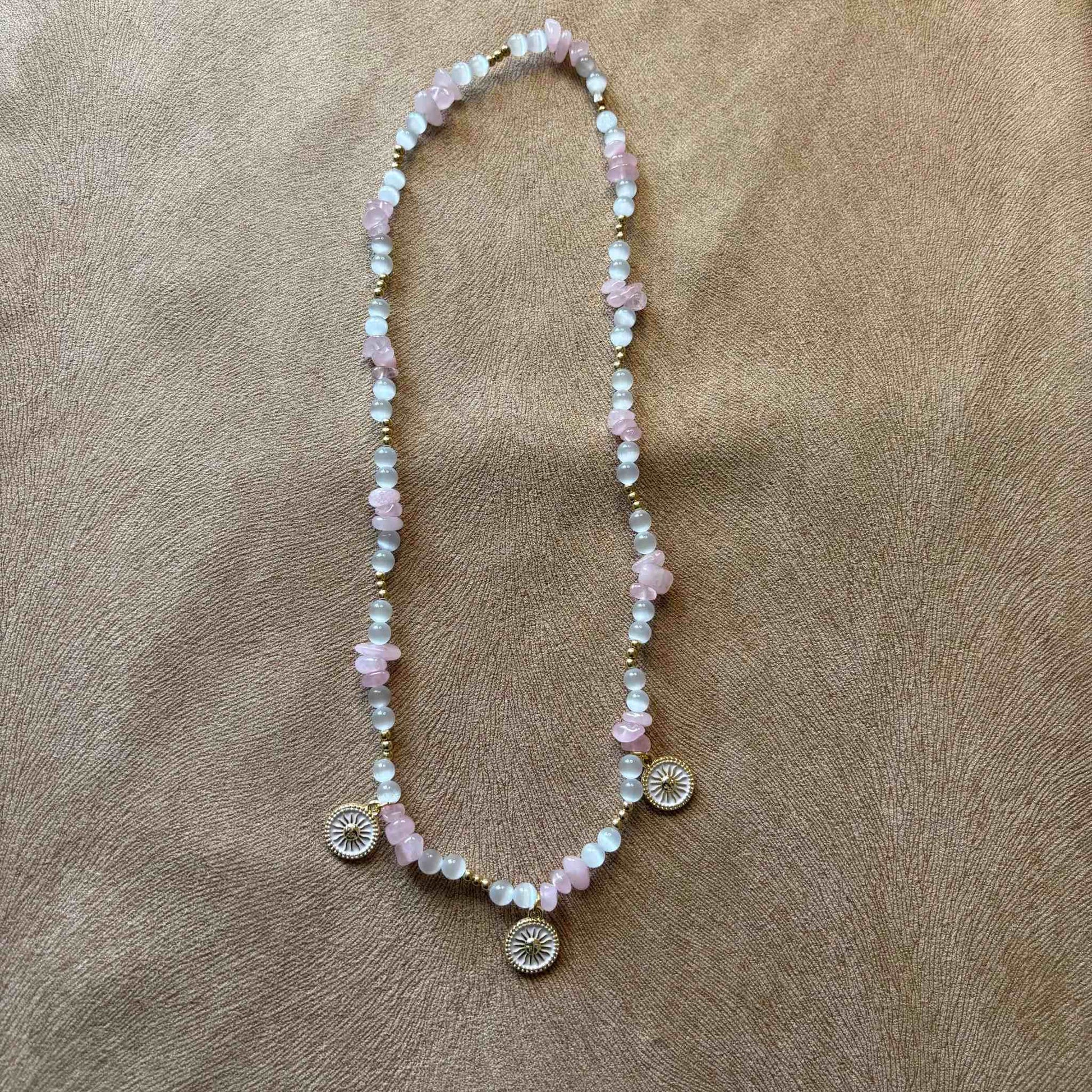 Collier artisanal en perles rose et blanches avec pendentifs décoratifs en forme de soleil bijou vendu sur le site internet prêtes à briller