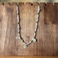Vue de près d'un collier artisanal en perles rose et blanches avec pendentifs décoratifs en forme de soleil bijou vendu sur le site internet prêtes à briller
