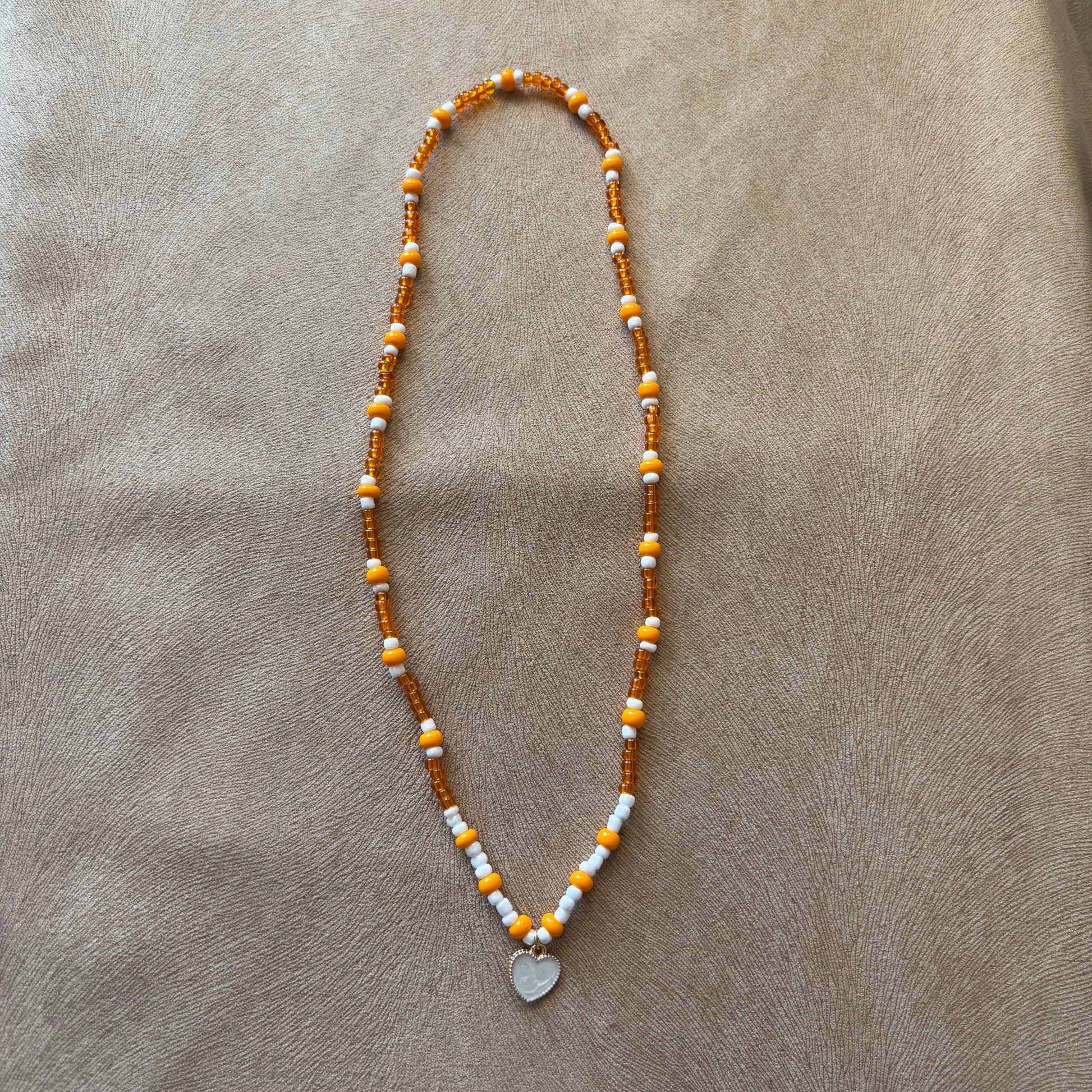Collier artisanal |Collier avec breloque cœur nacré |Perles de verre oranges et blanches sur élastique