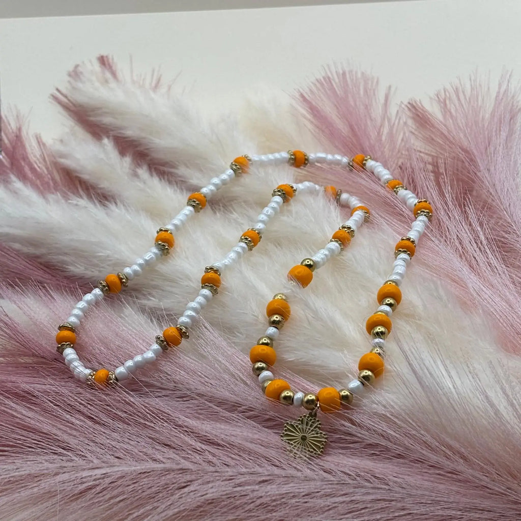 Collier en perles artisanal avec perles oranges et blanches et pendentif soleil doré