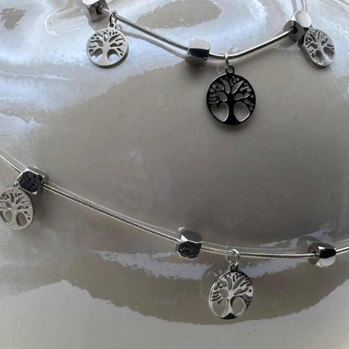 Collier fin argenté avec des breloques motif arbre de vie