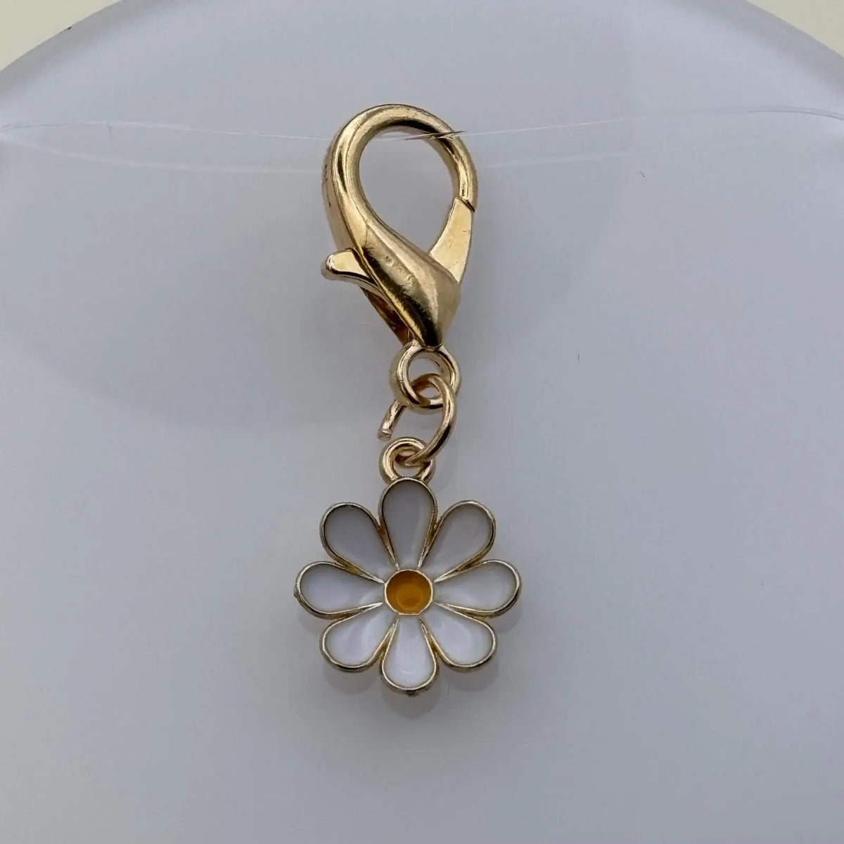 Bijou à accrocher doré en forme de marguerite blanche avec fermoir doré