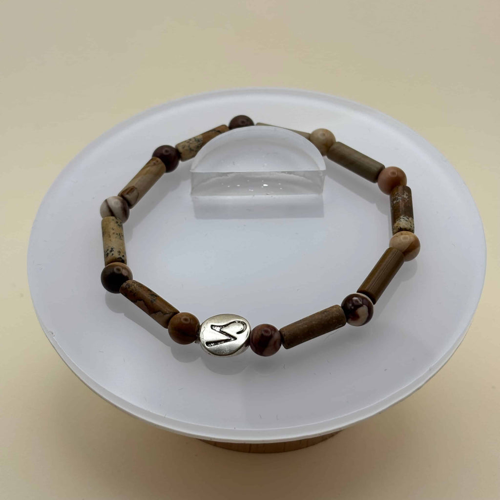 Un beau bracelet en perles sur élastique avec perles en porcelaine et en verre et médaillon avec le signe du capricorne