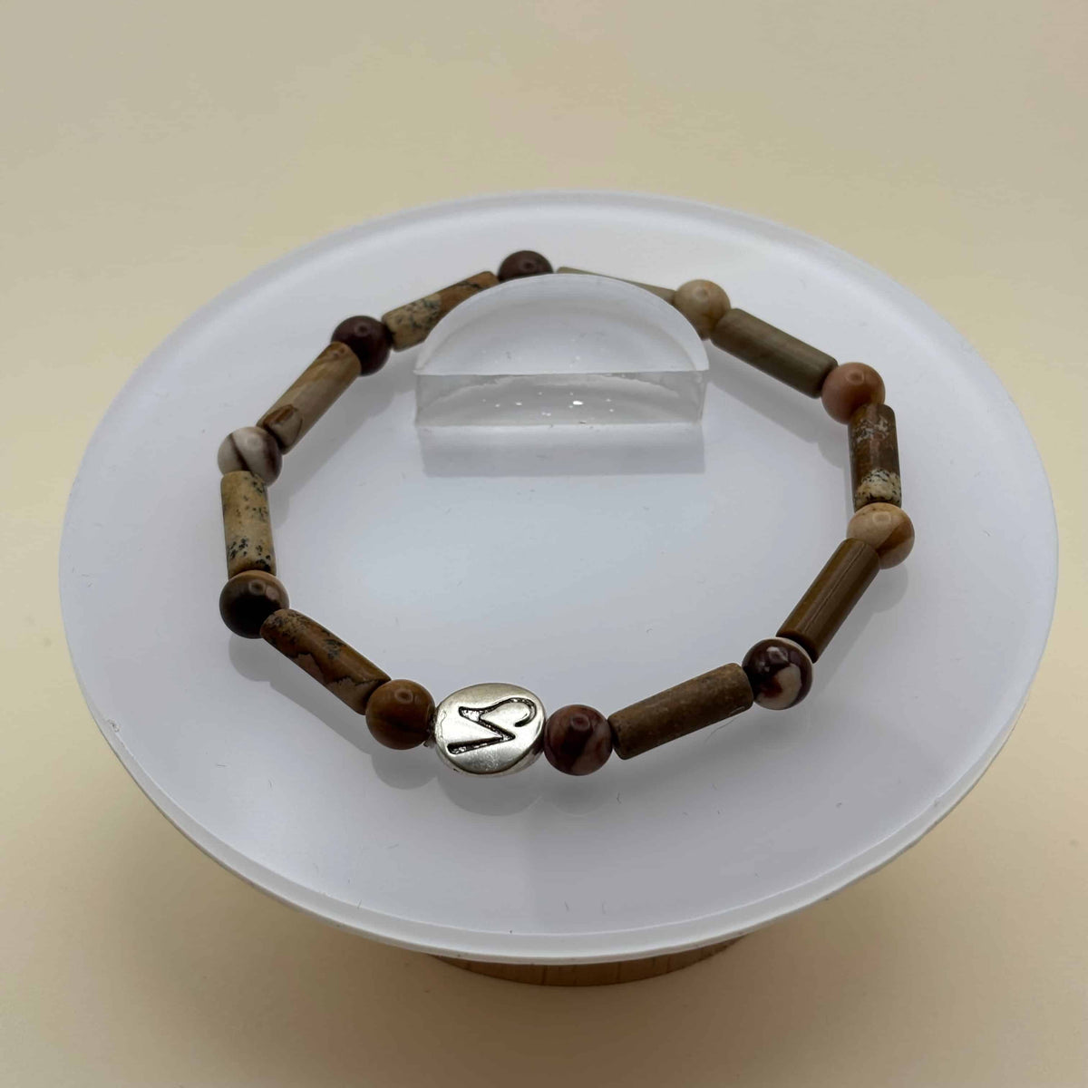 Un beau bracelet en perles sur élastique avec perles en porcelaine et en verre et médaillon avec le signe du capricorne