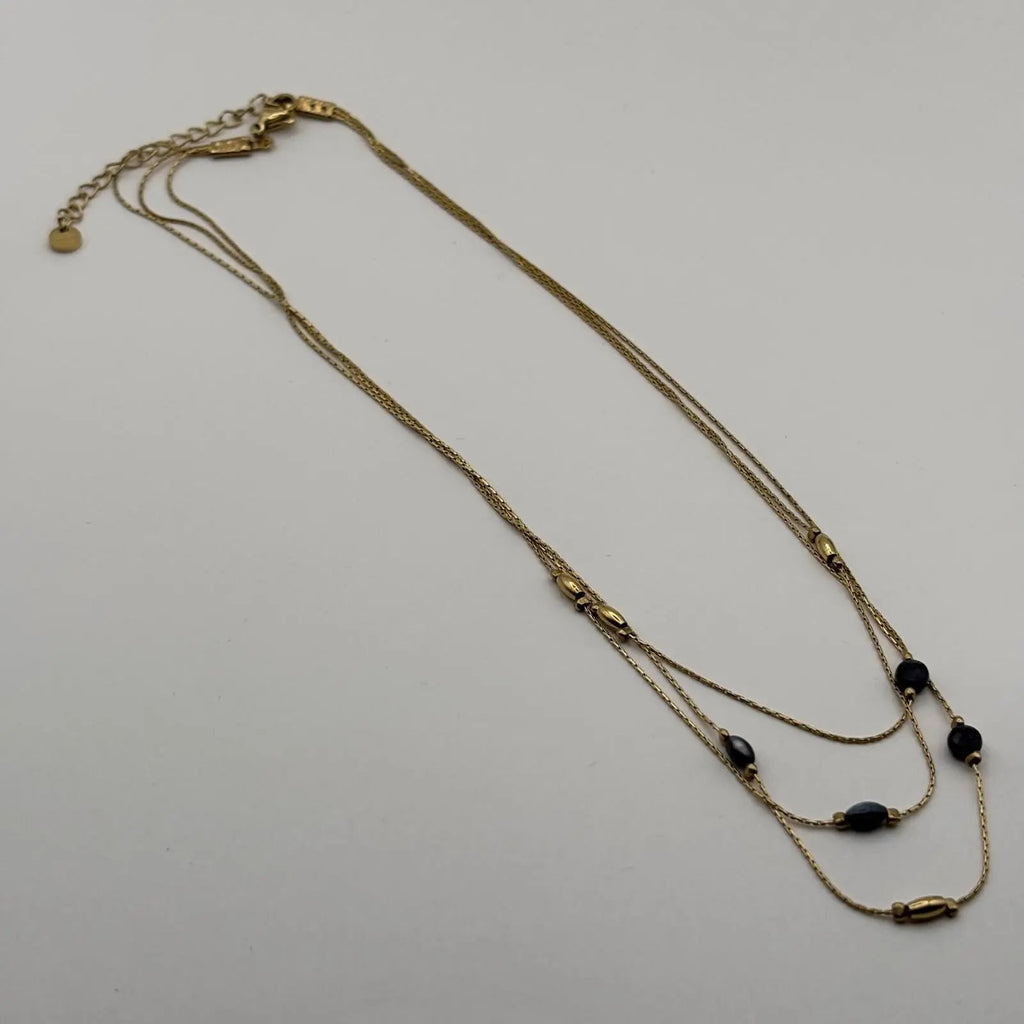 Vue de derrière d'un collier multirangs doré avec perles vertes