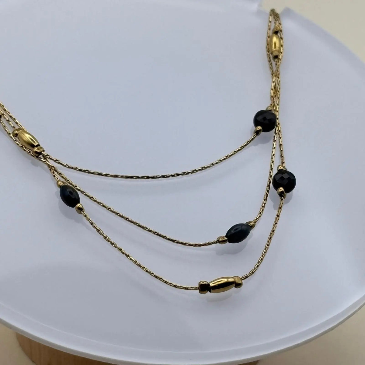 Un collier multirangs doré avec perles noires