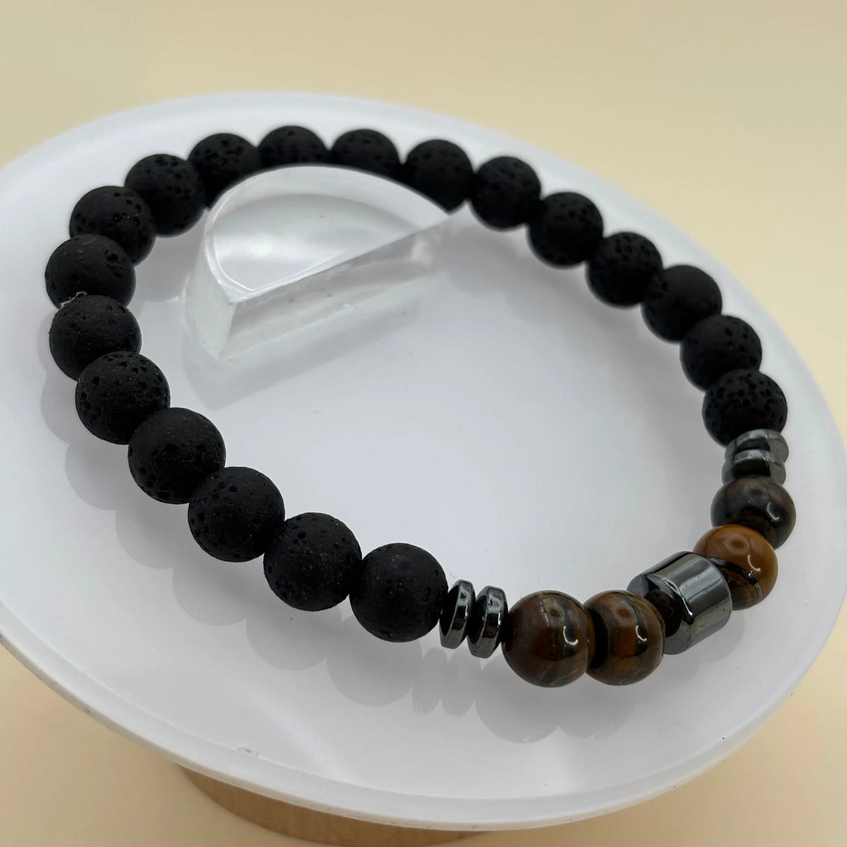 Un bracelet artisanal en perles pour homme sur élastique avec des perles de lave, oeil de tigre et hématite