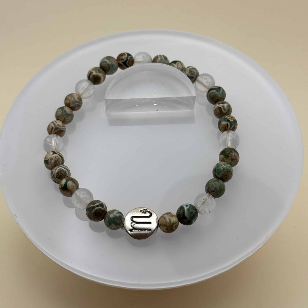 Un beau bracelet en perles sur élastique avec perles en porcelaine et en verre et médaillon avec le signe du scorpion